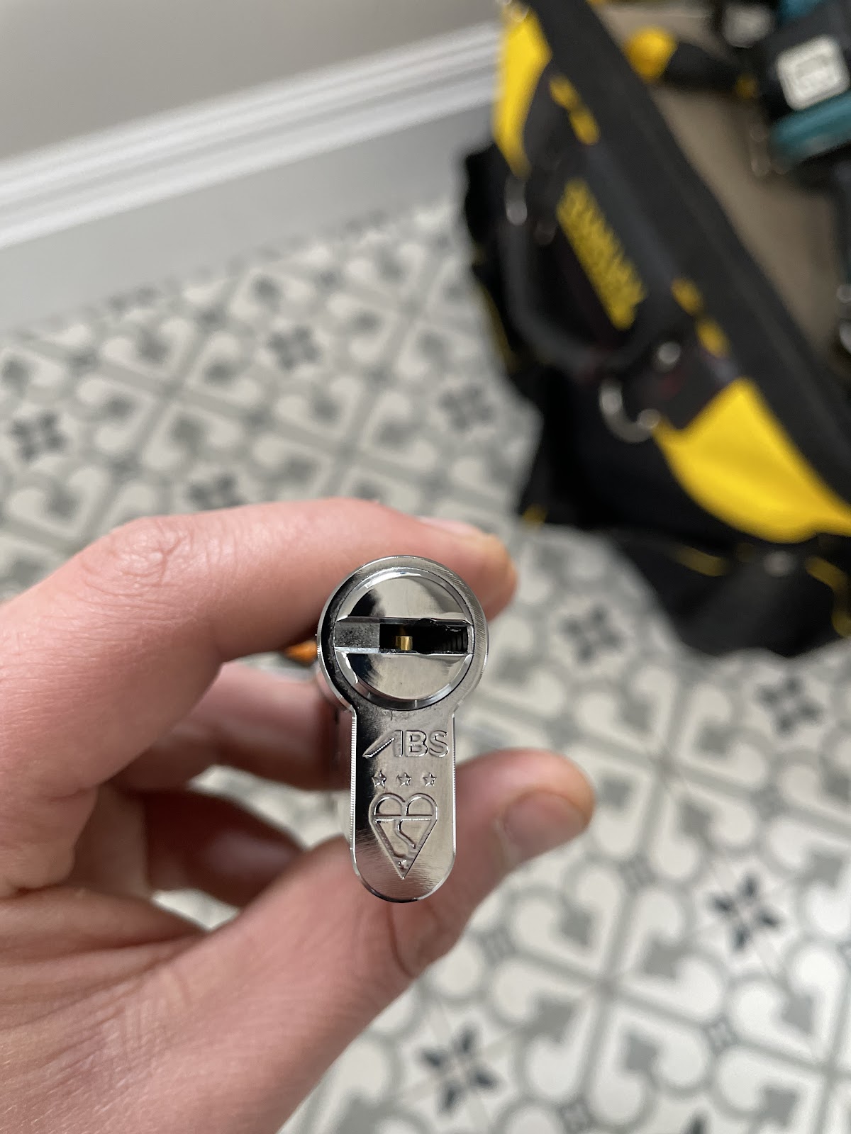 Locksmith holding a euro cylinder lock during a lock change in Manchester