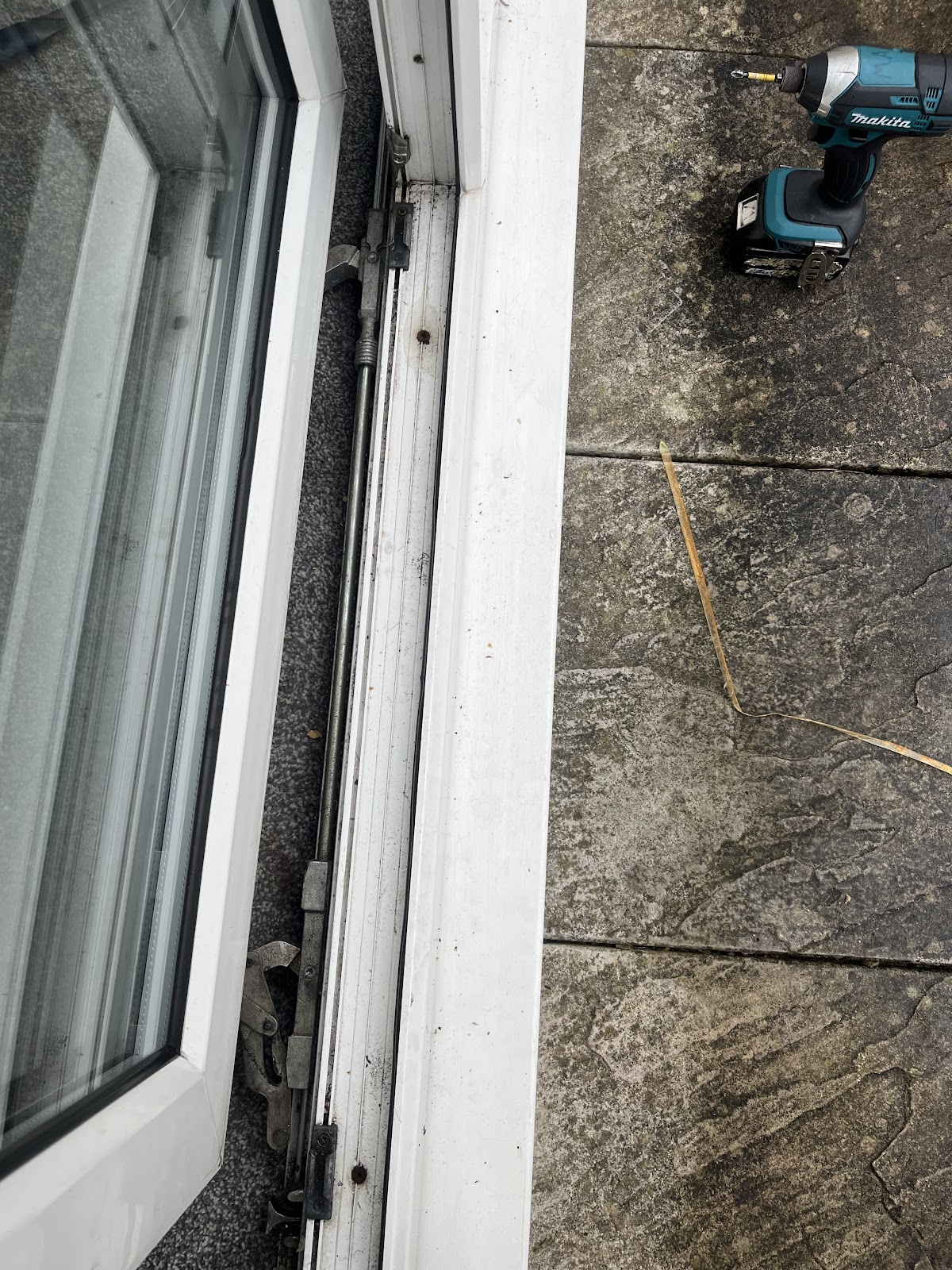 Close up of patio door track and roller mechanism during repair